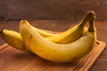 Ripe bananas in the peel on a wooden chopping Board.