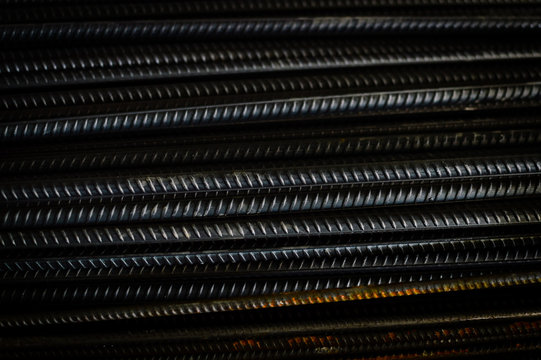 closeup of hard rods division rebars, used on stacked construction concrete background. industrial professional equipment pattern, stiff macro perspective image for reinforcement and construction.
