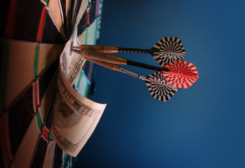 dart arrow hit the center target of dartboard and money