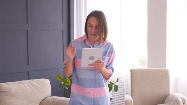 happy woman dancing with digital tablet