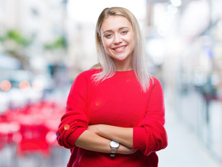 Young blonde woman wearing winter sweater over isolated background happy face smiling with crossed arms looking at the camera. Positive person.