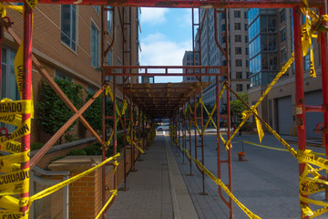 Fototapeta na wymiar Building facade Reconstruction sidewalk with yellow caution tape.