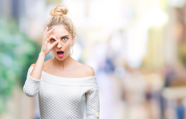 Fototapeta premium Young beautiful blonde and blue eyes woman over isolated background doing ok gesture shocked with surprised face, eye looking through fingers. Unbelieving expression.