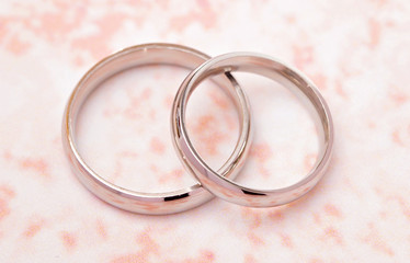 Simple White Gold Wedding Rings on a Pink Table