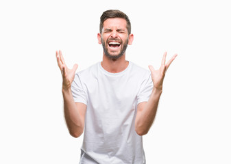 Fototapeta premium Young handsome man over isolated background celebrating mad and crazy for success with arms raised and closed eyes screaming excited. Winner concept