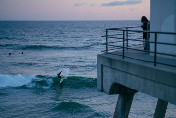 Surfer Rides Ocean Wave at Sunset 