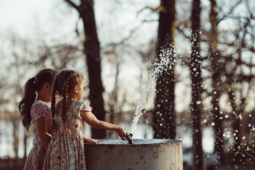Girls Play with Water Fountain in Park
