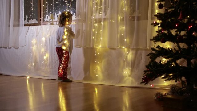 Boy of five years old is observing decorated window for Christmas period