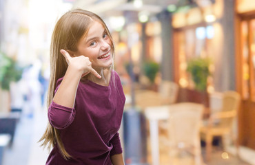 Young beautiful girl over isolated background smiling doing phone gesture with hand and fingers like talking on the telephone. Communicating concepts.