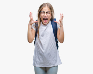 Young beautiful smart student girl wearing backpack over isolated background crazy and mad shouting and yelling with aggressive expression and arms raised. Frustration concept.