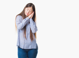 Young Chinese woman over isolated background sleeping tired dreaming and posing with hands together while smiling with closed eyes.