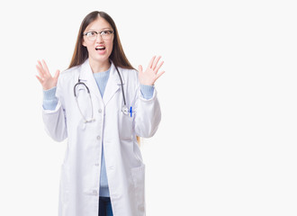 Young Chinese doctor woman over isolated background crazy and mad shouting and yelling with aggressive expression and arms raised. Frustration concept.