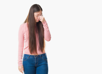 Young Chinese woman over isolated background wearing glasses tired rubbing nose and eyes feeling fatigue and headache. Stress and frustration concept.