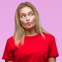 Young caucasian woman over isolated background making fish face with lips, crazy and comical gesture. Funny expression.