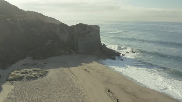 Aerial ascending shot and fly over of a cliff on the beach.