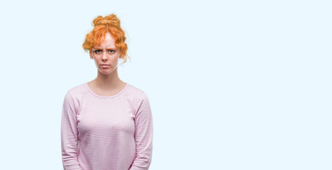 Young redhead woman skeptic and nervous, frowning upset because of problem. Negative person.