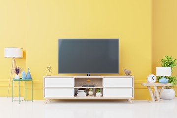 TV on wall with cabinet in modern empty room Include tree,lamp and many decorations on yellow wall background,3d rendering