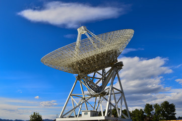 Array of satellite dishes or radio antennas against sky. Space o