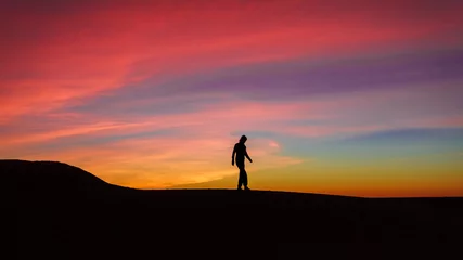 Foto auf Leinwand Silhouette of woman posing on sand dune during the sunset © Boy