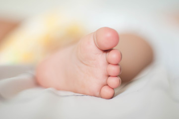 Isolated baby foot on white bed 