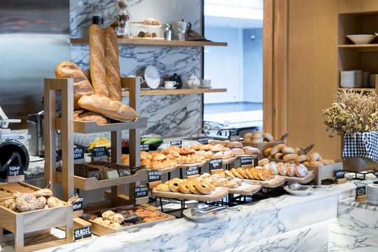 A variety of fresh homemade bread and bakery corner in luxury hotel breakfast buffet, restaurant interior.
