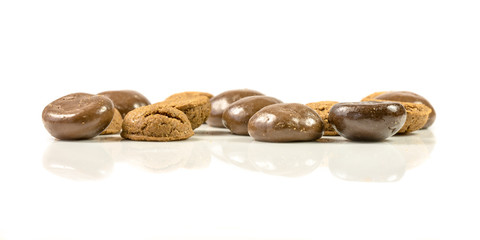 Pepernoten in a bunch of traditional and chocolate treats in a row on white background