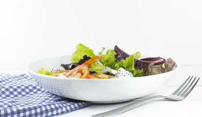 Healthy salad diet food concept, props decoration fork and blue Napery, tomatoes Dragon fruit and green and Purple Salad in white Plate on wood floor background, Close up, with copy space.
