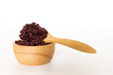 Wooden bowl and spoon with brown rice ready to eat. Deep Purple rice, Homnil rice.