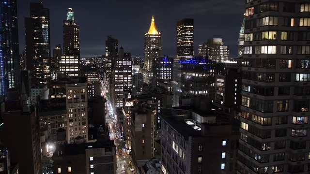 A wide high angle time lapse view buildings near Madison Square Park in Manhattan on a early Autumn night. The New York Life Tower is seen in the distance.  	