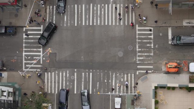 A top down bird's eye view of a typical Manhattan intersection as traffic and pedestrians travel on the streets below.  	