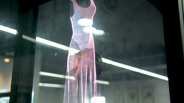 A hologram of a woman's dress on a holographic fan behind a window