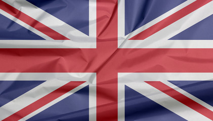 Fabric flag of The Union Jack. Crease of Union flag background, it is the national flag of the United Kingdom, white and red cross color on blue.