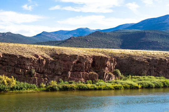 The Green River passes red-brown rock cliffs, wetlands, wide prairies, and mountains in Browns Park National Wildlife Refuge in northwestern Colorado