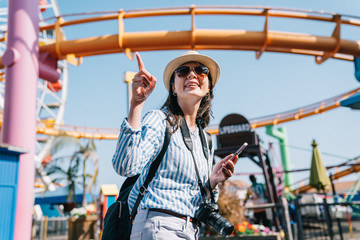 a female traveler pointing to roller coaster
