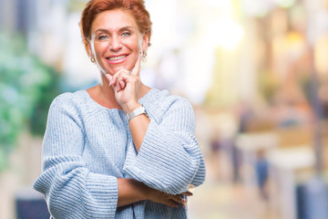 Atrractive senior caucasian redhead woman wearing winter sweater over isolated background looking...