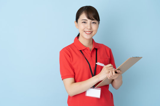 Portrait Of Young Asian Woman Wearing Red Polo Shirts On Blue Background