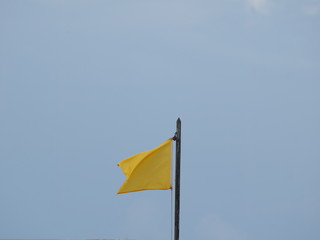 yellow flag on blue sky background