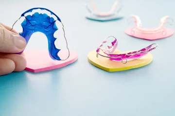 Schilderijen op glas Dental retainer orthodontic appliance on the blue background. © sujit