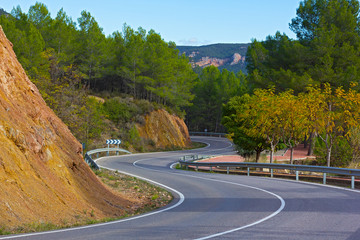 Road descending in the mountains of Valencia region in Spain. Scenic curving road among the...