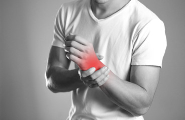 A man holding hands. Pain in the wrist. The hearth is highlighted in red. Close up. Isolated background