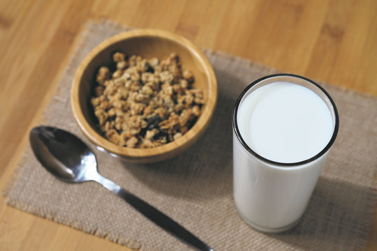 fresh milk in the glass with muesli background