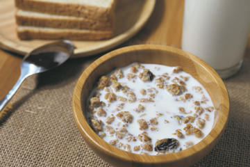 Healthy breakfast. Bowl of muesli with milk on wooden table