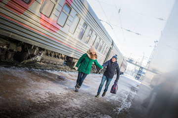 Couple is late for the train at railway station