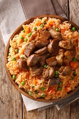 Mexican cuisine: spicy rice cooked with vegetables with tomato sauce and roasted pork close-up. Vertical top view