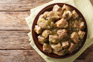 This authentic pork chile verde recipe. Tender pieces of pork slow cooked with a green chile sauce (salsa verde) closeup. horizontal top view