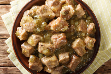 Mexican Pork Chile Verde is made of tender pieces of pork simmered in a flavorful tomatillo and chile broth closeup on the table. horizontal top view