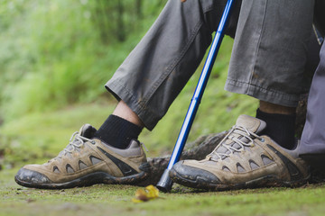 Adventure man hiking with backpack, hiking shoes in action on a mountain  trail path Close-up of male hikers shoes.