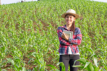 Asian girl standing and smiling in her corn field, Happy Farmer Concept