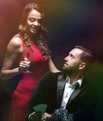 beautiful couple looking at playing cards at poker