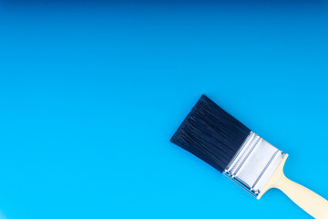 Paint brush on blue colour background with selective focus and crop fragment. Copy space conceptual